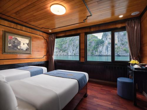 two beds in a boat room with windows at La Pandora Boutique Cruises in Ha Long