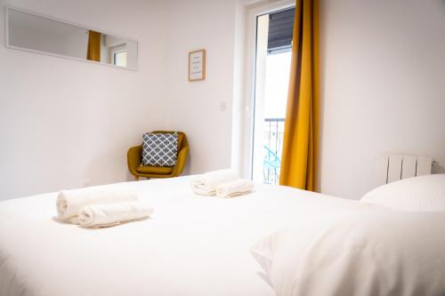 1 dormitorio con cama, ventana y silla en Superbe T2 centre ville dernier étage avec balcon en Valence