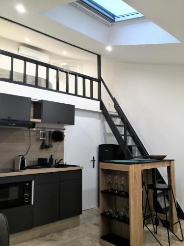 d'une cuisine avec une mezzanine aménagée avec un escalier. dans l'établissement Orange Théâtre Studio, à Orange