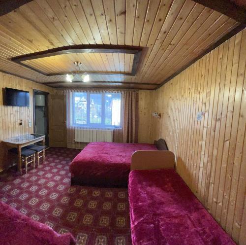 Zimmer mit 2 Betten und einem Tisch in der Unterkunft Sadyba Markevychiv ЧАН БАНЯ ЯРЕМЧЕ in Jaremtsche