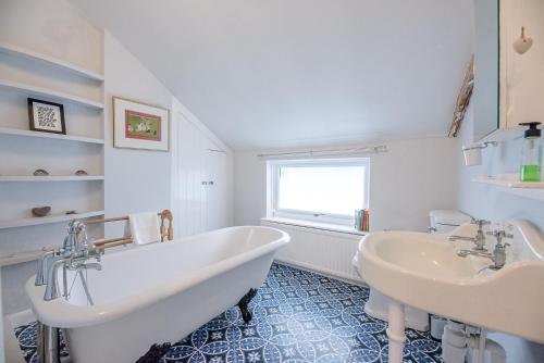 ein weißes Badezimmer mit zwei Waschbecken und einer Badewanne in der Unterkunft Jenny Rose Cottage Wickham Market Air Manage in Woodbridge