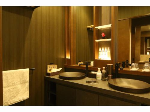 a bathroom with a sink and a mirror at Kashoutei Hanaya in Noboribetsu
