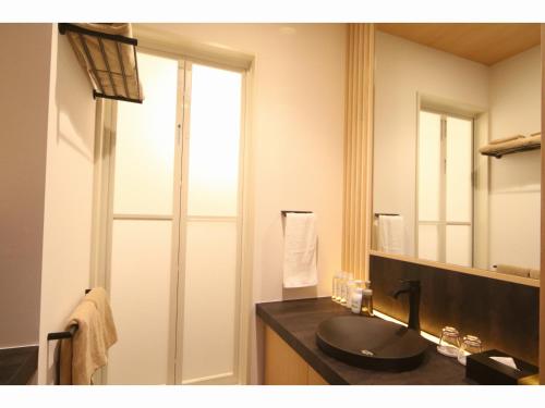 a bathroom with a black sink and a mirror at Kashoutei Hanaya in Noboribetsu