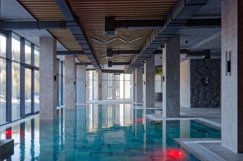 a pool in a building with blue water at Rest&Ski Spa Resort in Bukovel