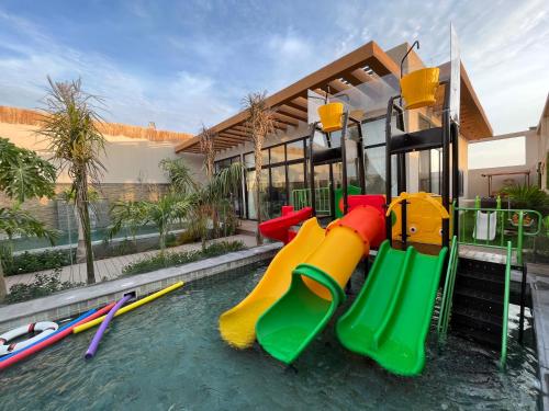 a pool of water with a playground with slides at Villa Bali Jeddah in Jeddah