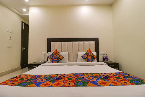 a bedroom with a large bed with a colorful blanket at FabHotel AGK in Haridwār