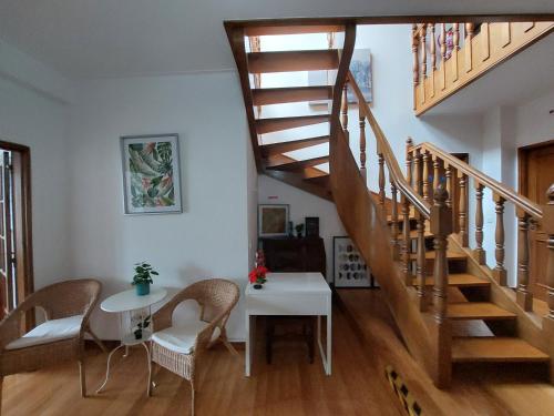 a living room with a staircase and a table and chairs at Guest House Sir Manuel - Unidade Senhora A Branca in Braga