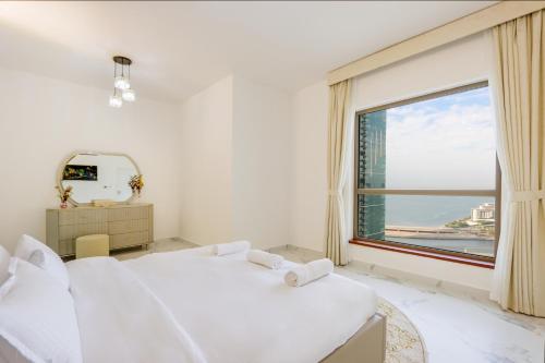 een slaapkamer met 2 witte bedden en een groot raam bij JBR The Walk Shams 4 - Fully Upgraded Sea view Lux 2 bedroom By Gardenia Holiday in Dubai