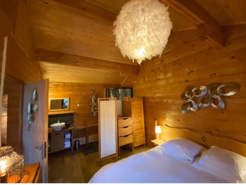 a bedroom with a bed and a chandelier at Le Petit Skieur B&B in Le Sappey-en-Chartreuse