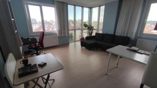 uma sala de estar com um sofá, mesas e janelas em Private Room in Istanbul #16 em Istambul