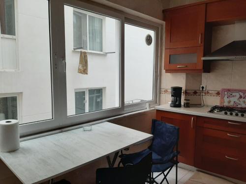 eine Küche mit einem Tisch, 2 Stühlen und 2 Fenstern in der Unterkunft Private Room in Istanbul #17 in Istanbul