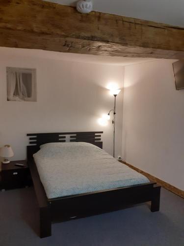 ein Schlafzimmer mit einem Bett in der Ecke eines Zimmers in der Unterkunft Le Grand Cerf in Nonancourt