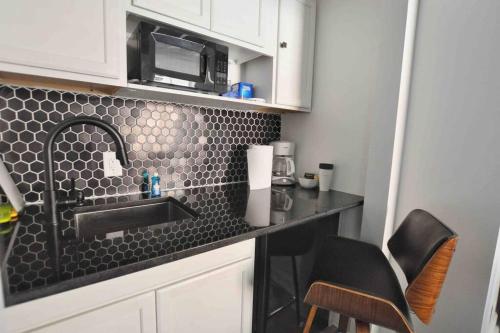 a kitchen counter with a sink and a microwave at Housepitality - The Brandenburg Suite - Efficiency in Columbus