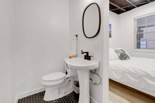 a bathroom with a toilet and a sink and a mirror at Housepitality - The Brandenburg Suite - Efficiency in Columbus