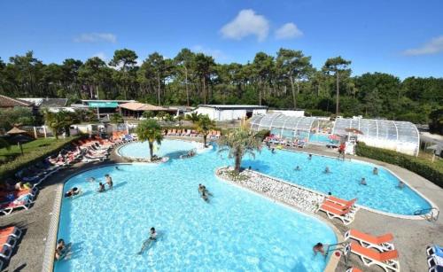- une piscine dans un complexe avec des personnes dans l'établissement Mobile home neuf climatisé 3 chambres sur le Bassin d'Arcachon, à Lège-Cap-Ferret