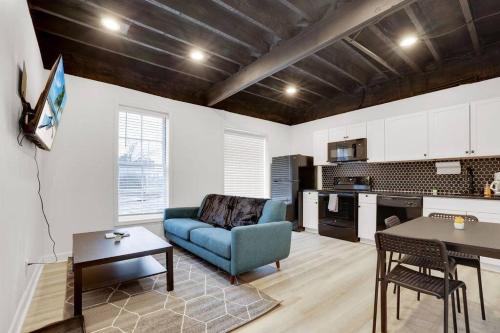 ein Wohnzimmer mit einem blauen Sofa und einer Küche in der Unterkunft Housepitality - The Neuschwanstein Flat in Columbus