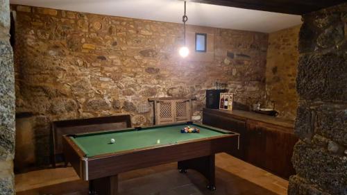 a pool table in a room with a stone wall at Los Ríos - Sierra de Gata in Torre de Don Miguel