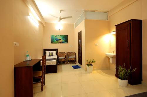 a room with a bed and a bathroom with a sink at Isha Residency in Alwaye