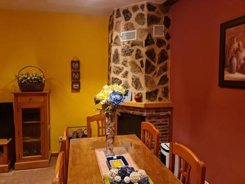 a dining room with a table and a fireplace at Alojamientos Carmen in Beteta