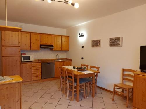 アンダロにあるAppartamenti Osti Sansoni Mariarosaのキッチン(木製キャビネット、テーブル、椅子付)