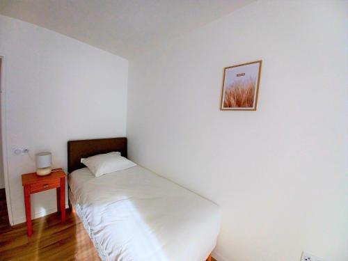 1 cama en una habitación con una foto en la pared en Domitys - Les Aiglons Blancs, en Briançon