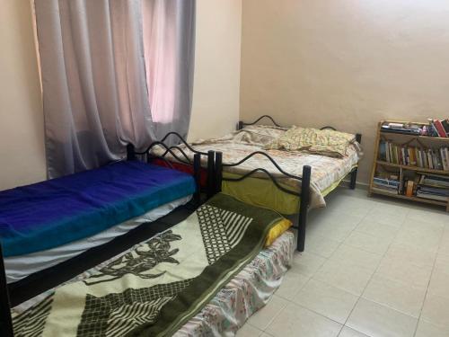 two twin beds in a room with a window at A Female room for tourists only غرفة للاناث الاجانب فقط in Bethlehem