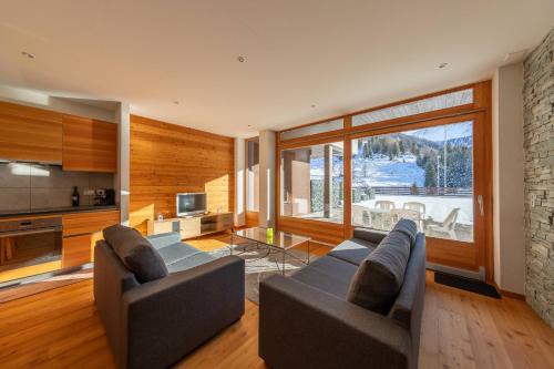 a living room with two couches and a television at Appartement ski-in, ski-out Siviez Rosablanche D 204B in Siviez
