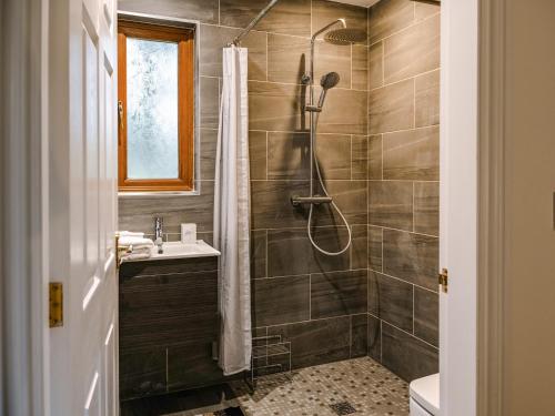 een badkamer met een douche en een wastafel bij Fir Tree Lodge in Sewerby