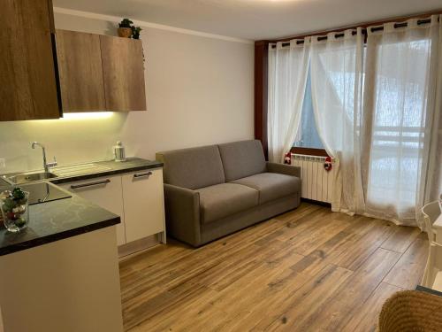 a living room with a couch and a kitchen at Cervinia Ski In Ski Out - Family Studio in Breuil-Cervinia