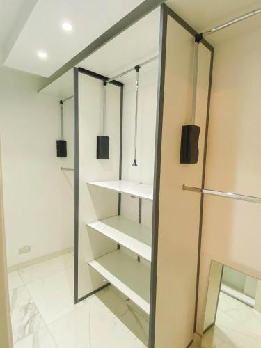 a walk in closet with white shelves and a mirror at The Blue Mill Penthouse with Beautiful Views in Naxxar