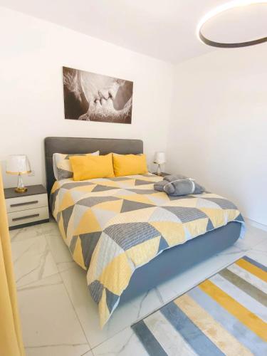 a bedroom with a bed with a yellow and blue comforter at The Blue Mill Penthouse with Beautiful Views in Naxxar