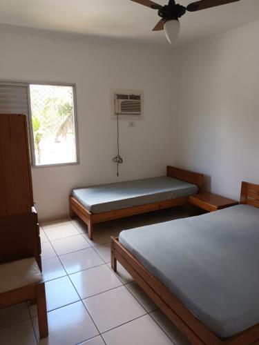 um quarto com duas camas e uma janela em Enseada- 400m Aquário. Apt espaçoso e aconchegante no Guarujá