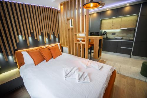 a bedroom with a bed with two towels on it at PleasureLUX MILMARI in Kopaonik