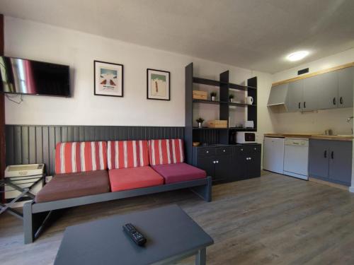 ein Wohnzimmer mit einem Sofa und einer Küche in der Unterkunft Apartament peu pistes 6 Edificio Fronterablanca-Bloc 1 in Pas de la Casa