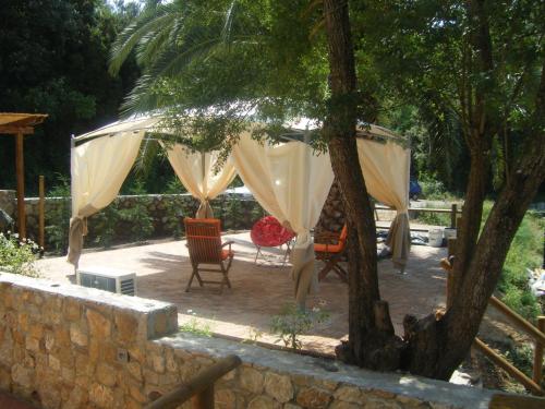 a patio with a table and chairs under a tree at Appartamento Giacomo in Cavo