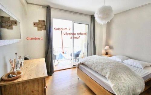 a bedroom with a bed and a table and a window at Vue de carte postale en hypercentre de Font-Romeu in Font-Romeu-Odeillo-Via