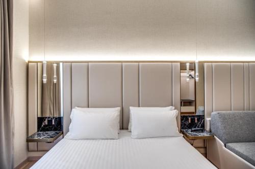 a bedroom with a bed with two pillows and a chair at CC Palace Hotel in Rome