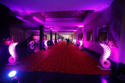 a hallway with purple lights in a building at Hotel Rajwada palace in Orchha