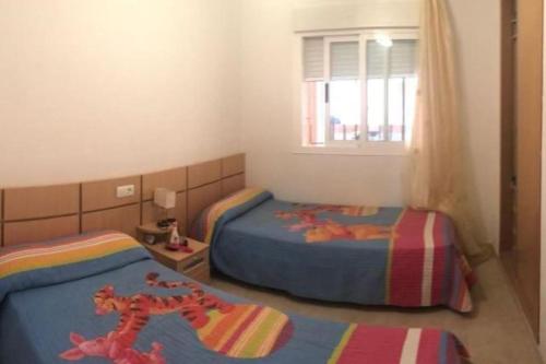 a bedroom with two beds and a window at Bajo con gran terraza en Ribera de Cabanes in Cabanes