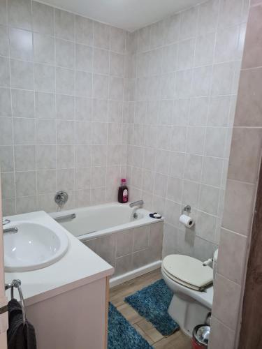a bathroom with a tub and a toilet and a sink at 4 Main Sail Port St Francis in St Francis Bay