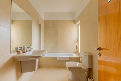 a bathroom with a sink and a toilet and a tub at Moradia Villa Brava - Algarve in Alvor
