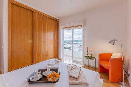 a living room with a table and an orange chair at Moradia Villa Brava - Algarve in Alvor