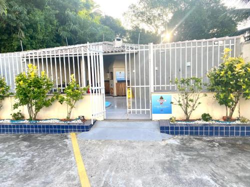 a white gate in front of a building at Temporada Ilhéus 2/4 in Ilhéus