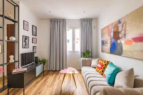 a living room with a couch and a tv at Eva Boutique Apartment in Funchal