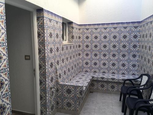 uma parede de azulejos com um banco num quarto em Best place Mahdia, Sea and Downtown em Mahdia
