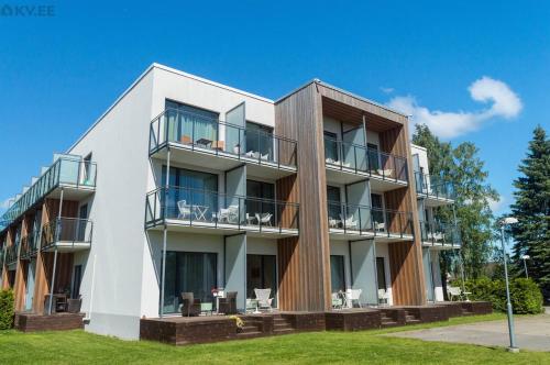a white building with balconies and tables and chairs at Sunny Aisa Apartment in Pärnu