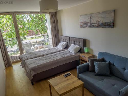 - un salon avec un lit et un canapé dans l'établissement Sunny Aisa Apartment, à Pärnu