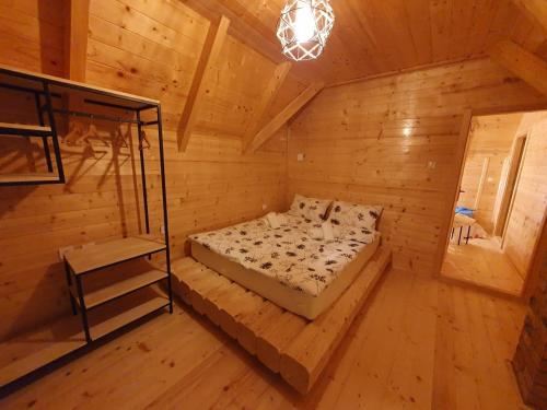 een slaapkamer met een bed in een houten kamer bij Anna's Mountain House in Kolašin