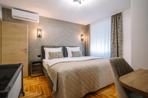 una habitación de hotel con una cama y un televisor en Apartments Hana City Center, en Livno