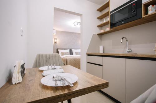 - une cuisine avec une table, des assiettes et des ustensiles dans l'établissement Apartments Hana City Center, à Livno